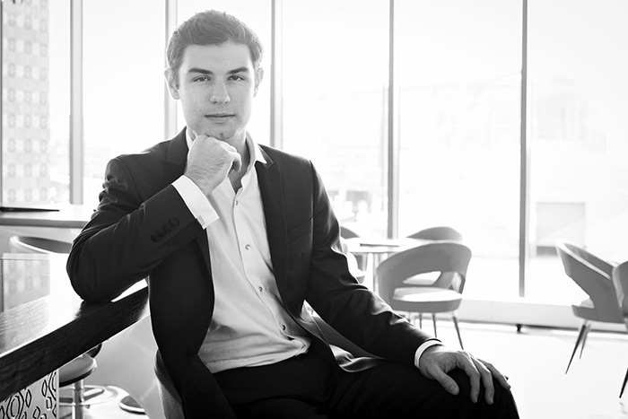 Black and white photo of pianist Drew Petersen sitting at a piano