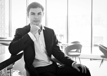 Black and white photo of pianist Drew Petersen sitting at a piano