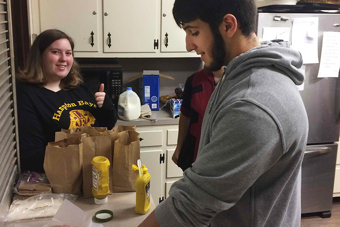Hampton Bays High School Leo Club members Zoey Smith and Michael Del Rey prepare food for Maureen’s Haven