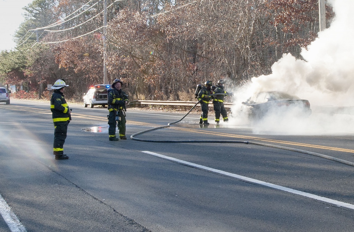 East Hampton firefighters extinguish a car fire Monday afternoon on Montauk Highway.