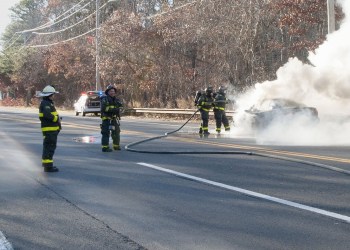 East Hampton firefighters extinguish a car fire Monday afternoon on Montauk Highway.