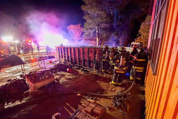 East Hampton firefighters extinguish a dumpster fire Sunday.