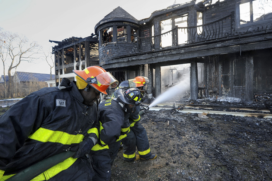 Fire fighters soak down a Northwest Woods house on New Year's Day.