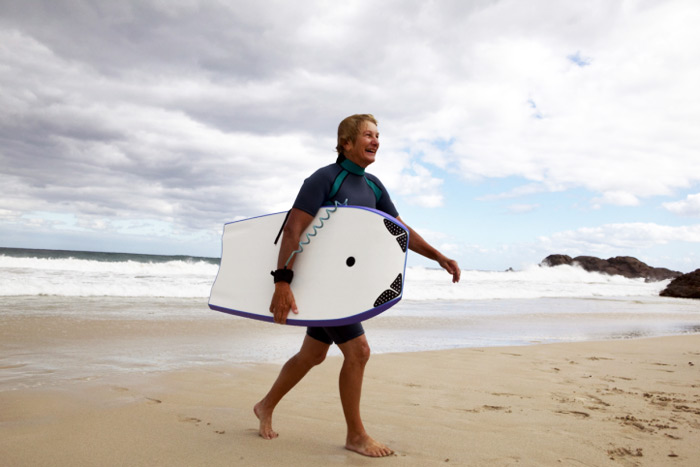 Mature boogie boarder surf