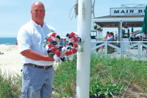 Francis Mott of Main Beach holds the wreath that was thrown into the ocean