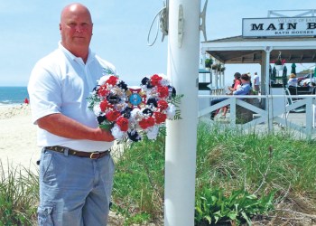 Francis Mott of Main Beach holds the wreath that was thrown into the ocean