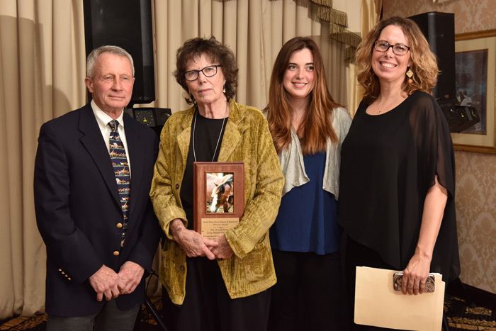 Diane and Melinda Novak, with daughter Chela, receive the Phoenix Award from Dr. John Andresen