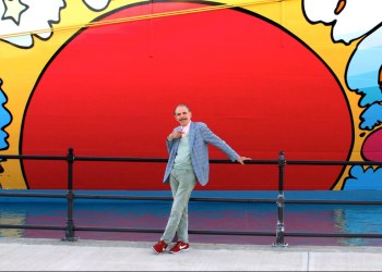 Peter Max poses with the Norwegian Breakaway cruise ship.