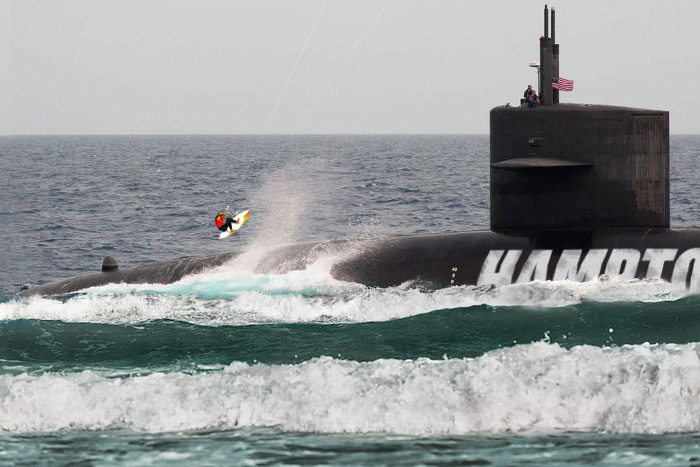A kiteboarder attempts to jump over the Hamptons Police Department submarine