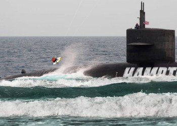 A kiteboarder attempts to jump over the Hamptons Police Department submarine