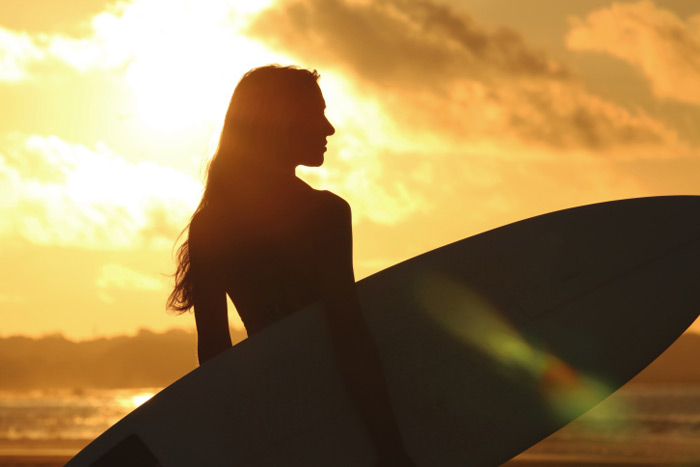 Surfer girl at sunset