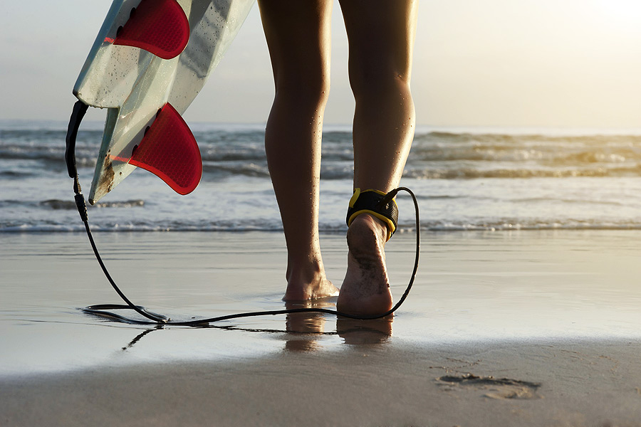 Walking into the water with a surfboard