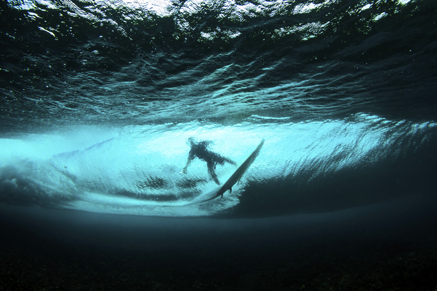 surfer in wave from underwater