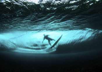 surfer in wave from underwater