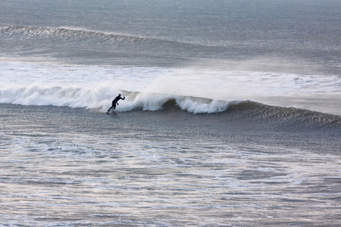 Surfing a wave wide shot
