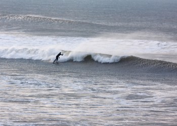 Surfing a wave wide shot