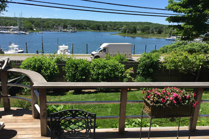 Beach, boats, trucks, telephone wires, deck on Three Mile Harbor Road