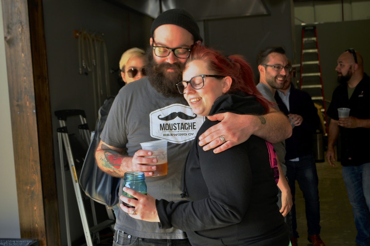 Owners Matt and Lauri Spitz embrace at the soft opening of Moustache Brewing Company’s tasting room, which will have its grand opening this Saturday on Hallett Street in Riverhead.
