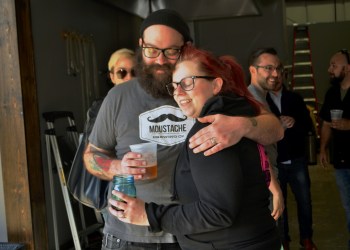 Owners Matt and Lauri Spitz embrace at the soft opening of Moustache Brewing Company’s tasting room, which will have its grand opening this Saturday on Hallett Street in Riverhead.