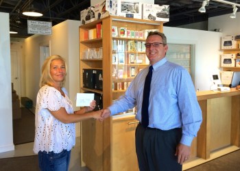 GeekHampton director of operations Amy O'Donnell, presents a $500 BookHampton gift card to Scott Fisher, the director of technology at Pierson High School.