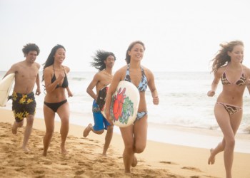 surfers running on beach