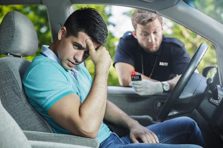 Man looking embarrassed in his car as BBITF cop checks his wealth and learns he's too poor to enter the Hamptons