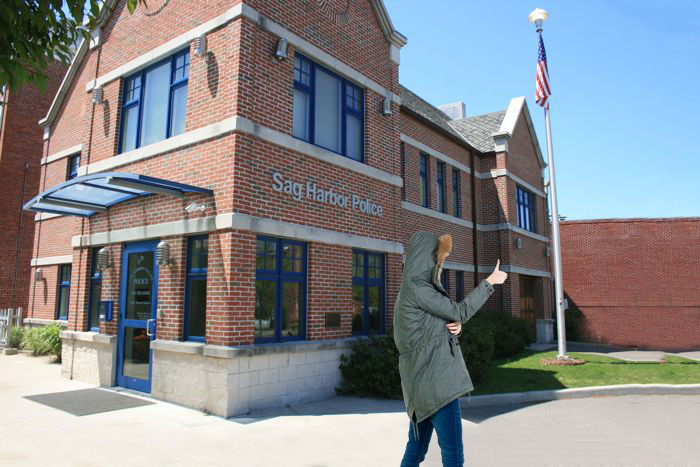 Woman in heavy winter coat doing a thumbs up outside Sag Harbor Police headquarters