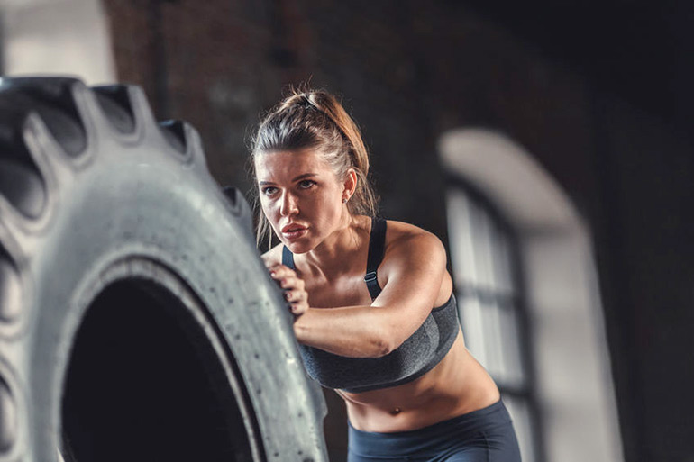 CrossFit woman pushing tire