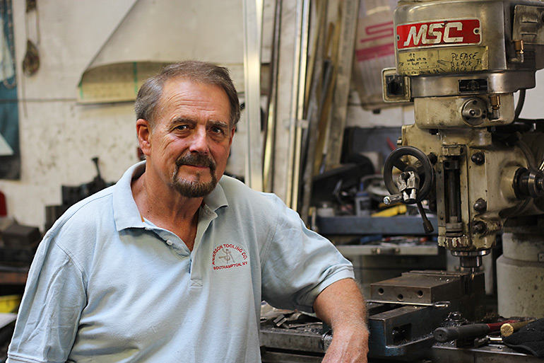 Gary Anderson standing next to a machine in his Anderson Tooling shop