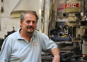Gary Anderson standing next to a machine in his Anderson Tooling shop