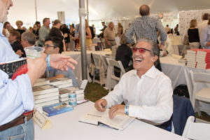 Geraldo Rivera signs his book and laughs with a fan