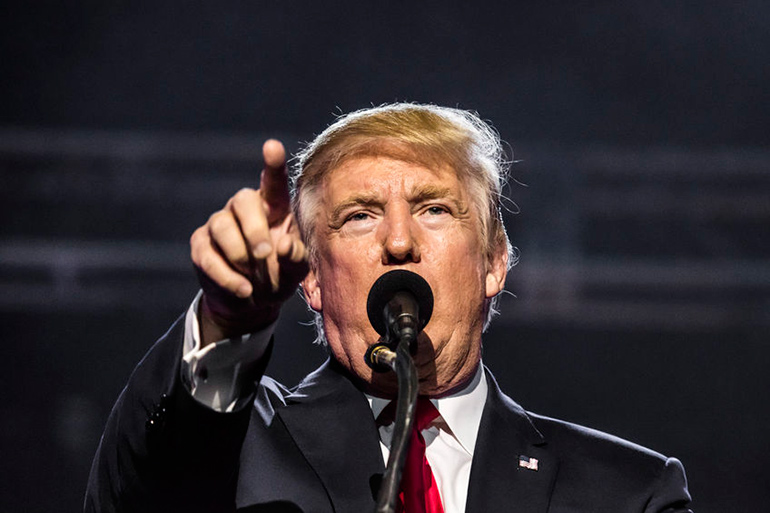 Donald Trump pointing behind microphone