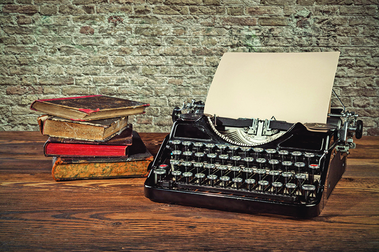 41649561 - retro typewriter placed on wooden planks. old brick wall as background with copyspace.