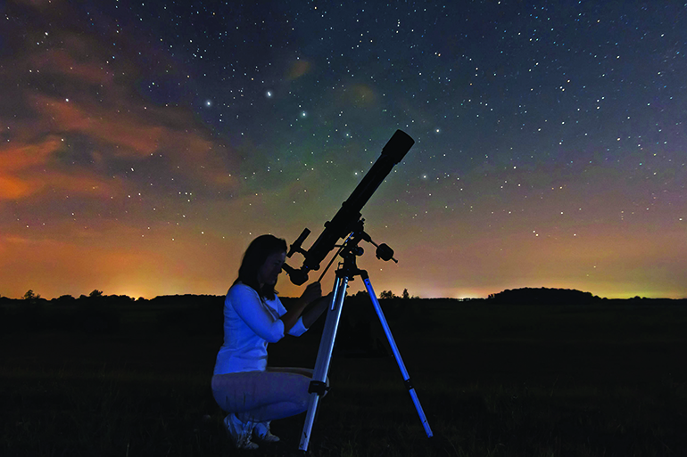 47066493 - woman looking through a telescope watching the stars. woman under night sky, constellations, draco, ursa major, big dipper, botes