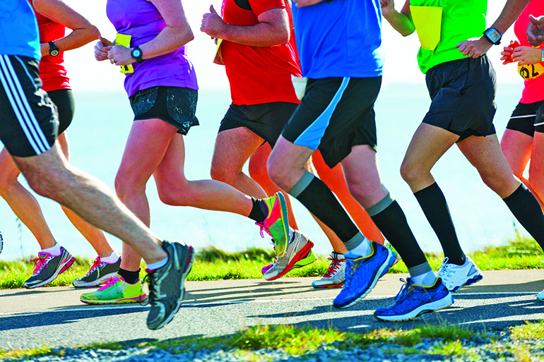 group of runners compete in the race on coastal road