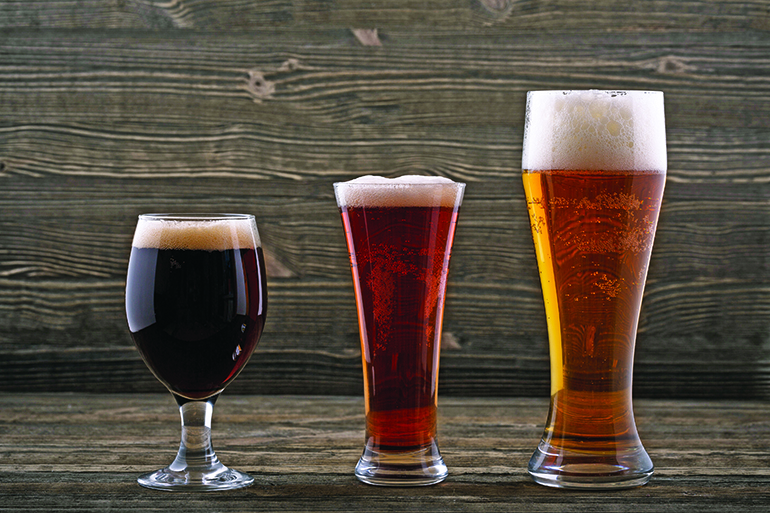 Various types of beer on a wooden background