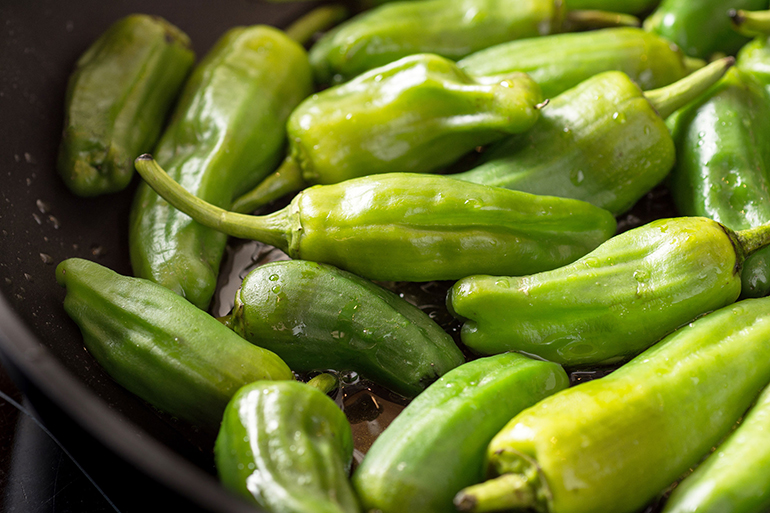 Green padron peppers in the frying pan. pimientos de padron.