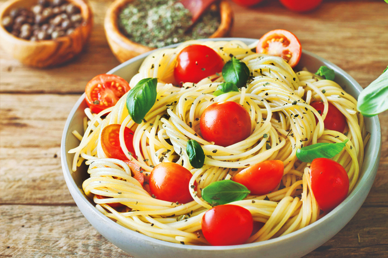 italian cuisine. pasta with olive oil, garlic, basil and tomatoes. spaghetti with tomatoes