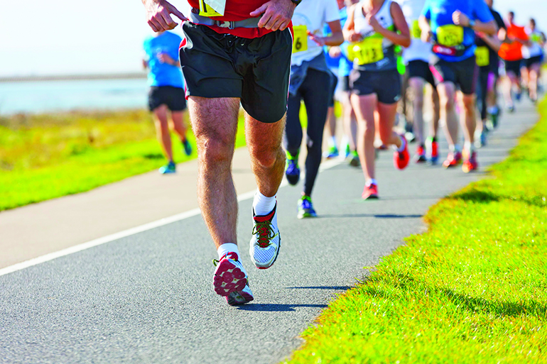 41128814 - group of runners compete in the race on coastal road