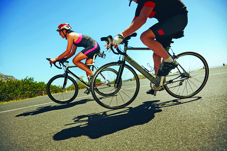 39042762 - action shot of a racing cyclists. cyclist riding bicycles down hill on country road. practicing for competition.
