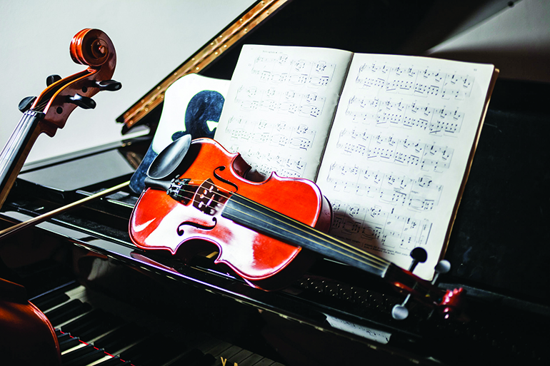 32529176 - classical music scene: violin and score on a piano