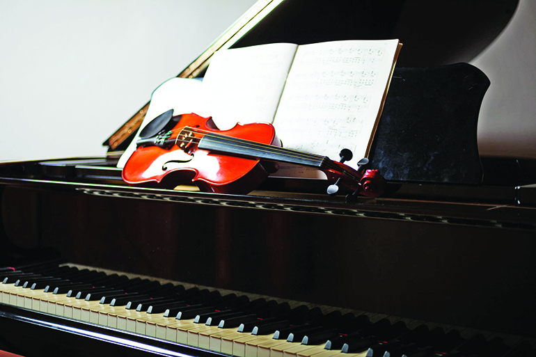 Classical music scene: violin and score on a piano