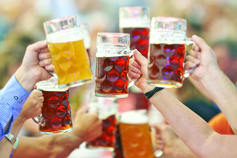24530995 - oktoberfest beer drinkers raise glass