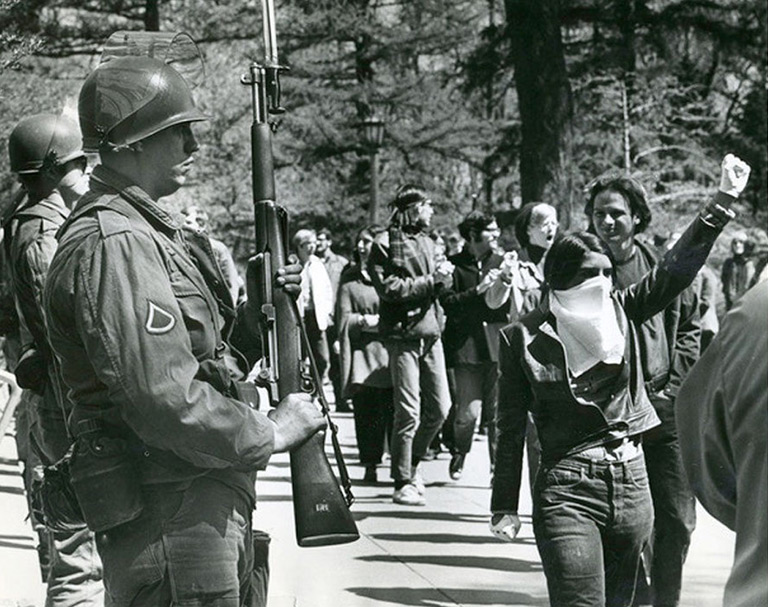 Marchers and soldiers in "The War at Home"