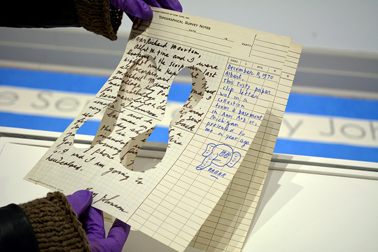 Frost holds a Ray Johnson letter with cutouts