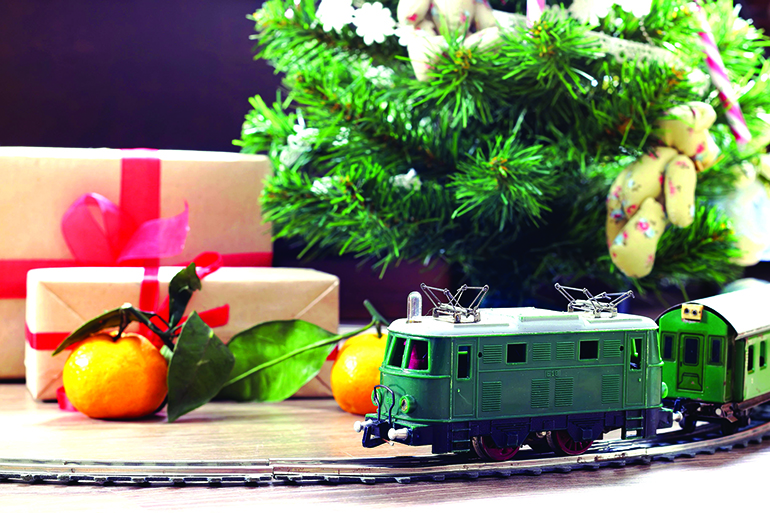 little old toy train on the track and with a motor under the Christmas tree decorated