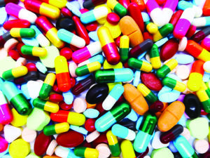 Many colorful pills, tablets and capsules medical drug. Concept of drug use and drug overdose.