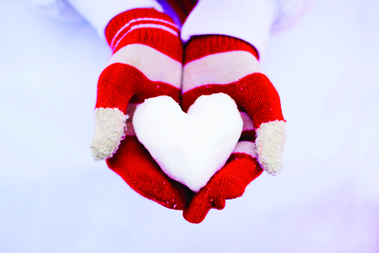 romantic white snow and red gloves holding it
