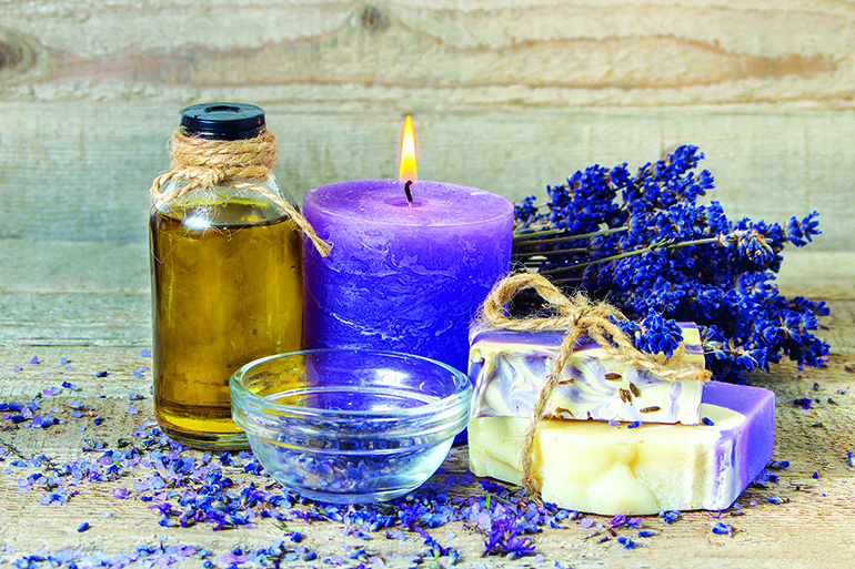 Spa lavender concept. Lavender oil, lavender flowers, handmade soap and sea salt with burning aromatherapy candle.