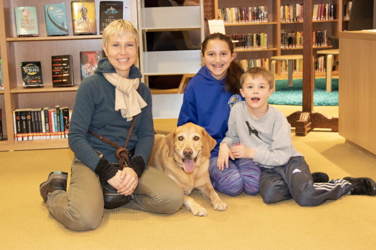 Gail Murphy (left) brings Wally to the library to work with kids like Isabelle, age 12, and Joly Evan, age 8